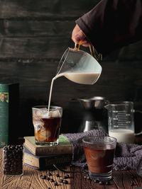 Pouring milk in a coffe cup in vintage background 