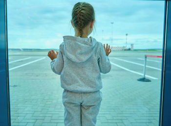 Rear view of boy standing in city