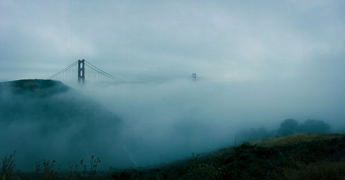 Low angle view of mountain against sky during foggy weather