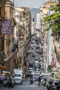 Vehicles on city street amidst buildings