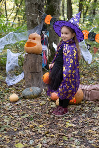 Halloween. cute little girl in witch costume with jack o lantern having fun outdoor