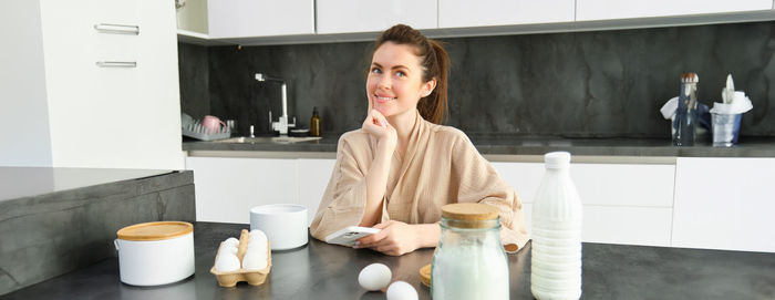 Portrait of young woman drinking coffee at home