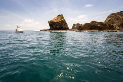 Scenic view of rock formation in sea against sky