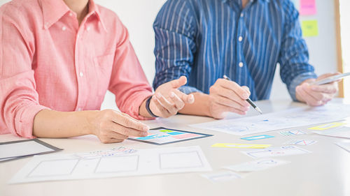 Midsection of people working on table