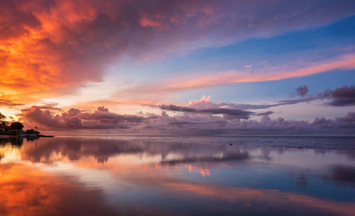 Scenic view of infinity swimming pool against romantic sky at sunset