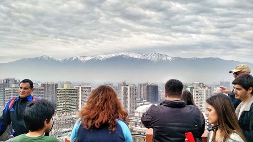 People looking at cityscape against sky