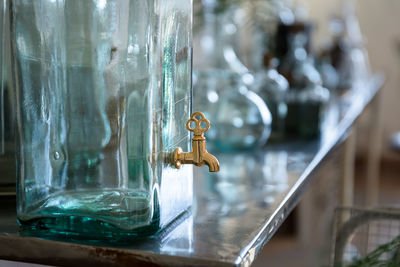 Close-up of faucet in glass container