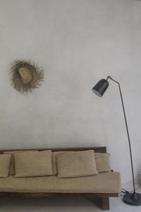 Close-up of electric lamp on wall at home