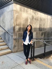 Portrait of woman standing on staircase