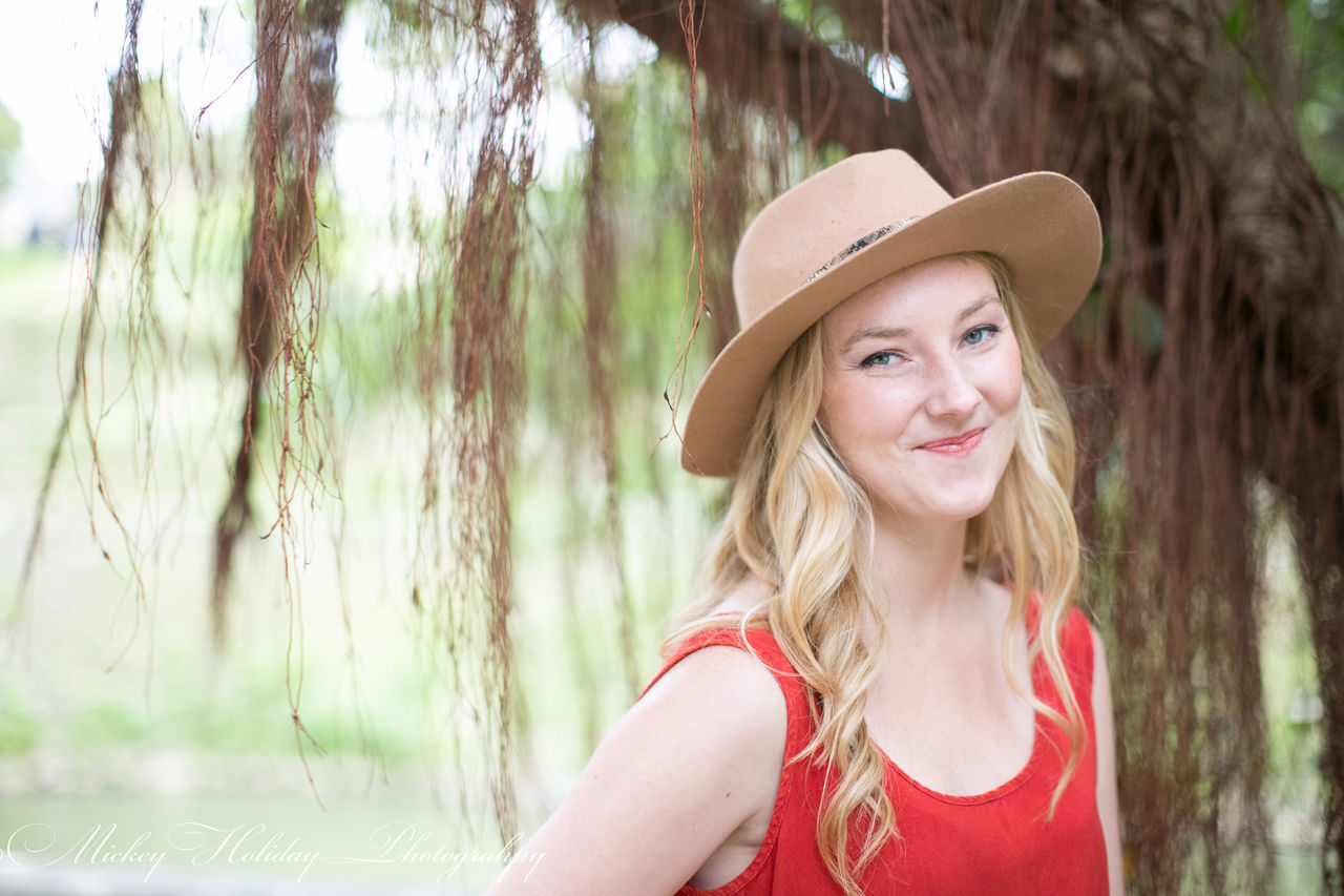 young adult, portrait, person, looking at camera, lifestyles, focus on foreground, young women, front view, leisure activity, headshot, smiling, long hair, tree, casual clothing, sunglasses, waist up, head and shoulders