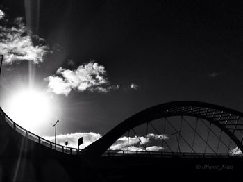 Low angle view of silhouette bridge against sky in city