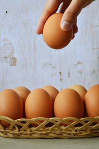 Close-up of hands holding eggs in basket