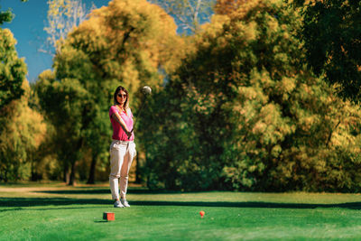 Beautiful female golfer getting ready on the tee box