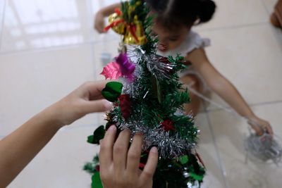 Mother and daughter decorating christmas tree at home