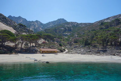 Scenic view of sea and mountains against clear sky