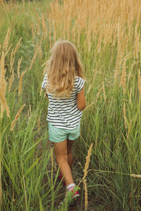 Child walking on a trail , tall grass