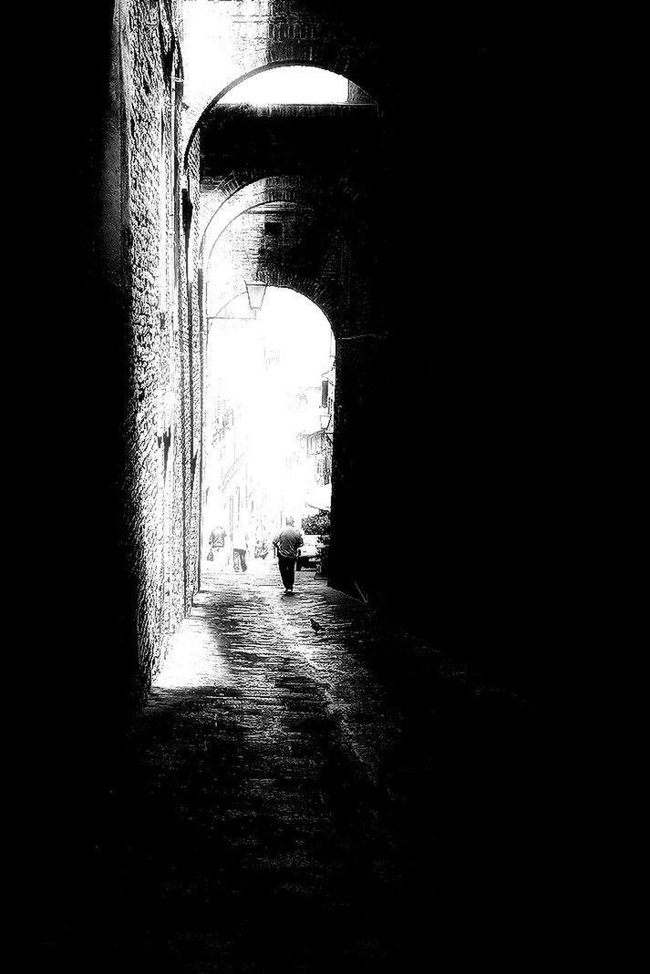 walking, lifestyles, men, indoors, rear view, tunnel, full length, the way forward, silhouette, leisure activity, built structure, architecture, person, dark, arch, standing, street, wall - building feature