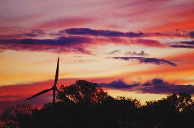 Low angle view of silhouette trees against dramatic sky