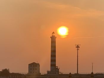 Silhouette lighthouse against orange sky sunny cavallino-treporti italy europe 