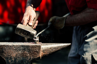 Midsection of man working on metal