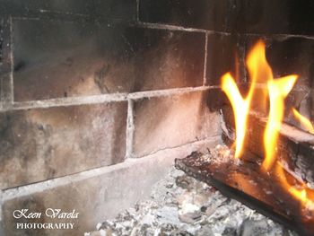 Close-up of fire on wood against wall