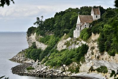 View of castle by sea against sky