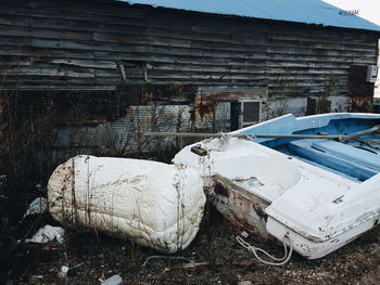 Abandoned boat against wooden wall