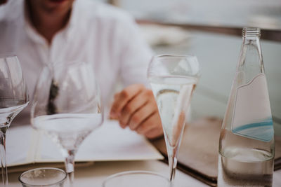 Midsection of man holding beer glass in restaurant