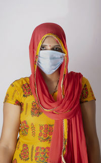 Portrait of woman standing against wall