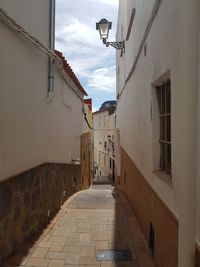 Narrow street amidst buildings against sky