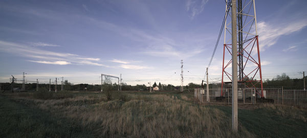 Electricity pylon on field against sky