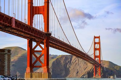 Suspension bridge against cloudy sky