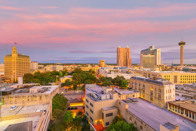 High angle view of city buildings against cloudy sky