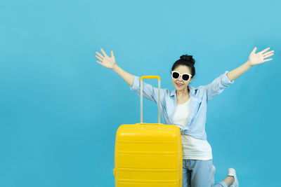 Woman wearing sunglasses against blue background