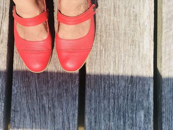 Low section of woman standing on wooden floor