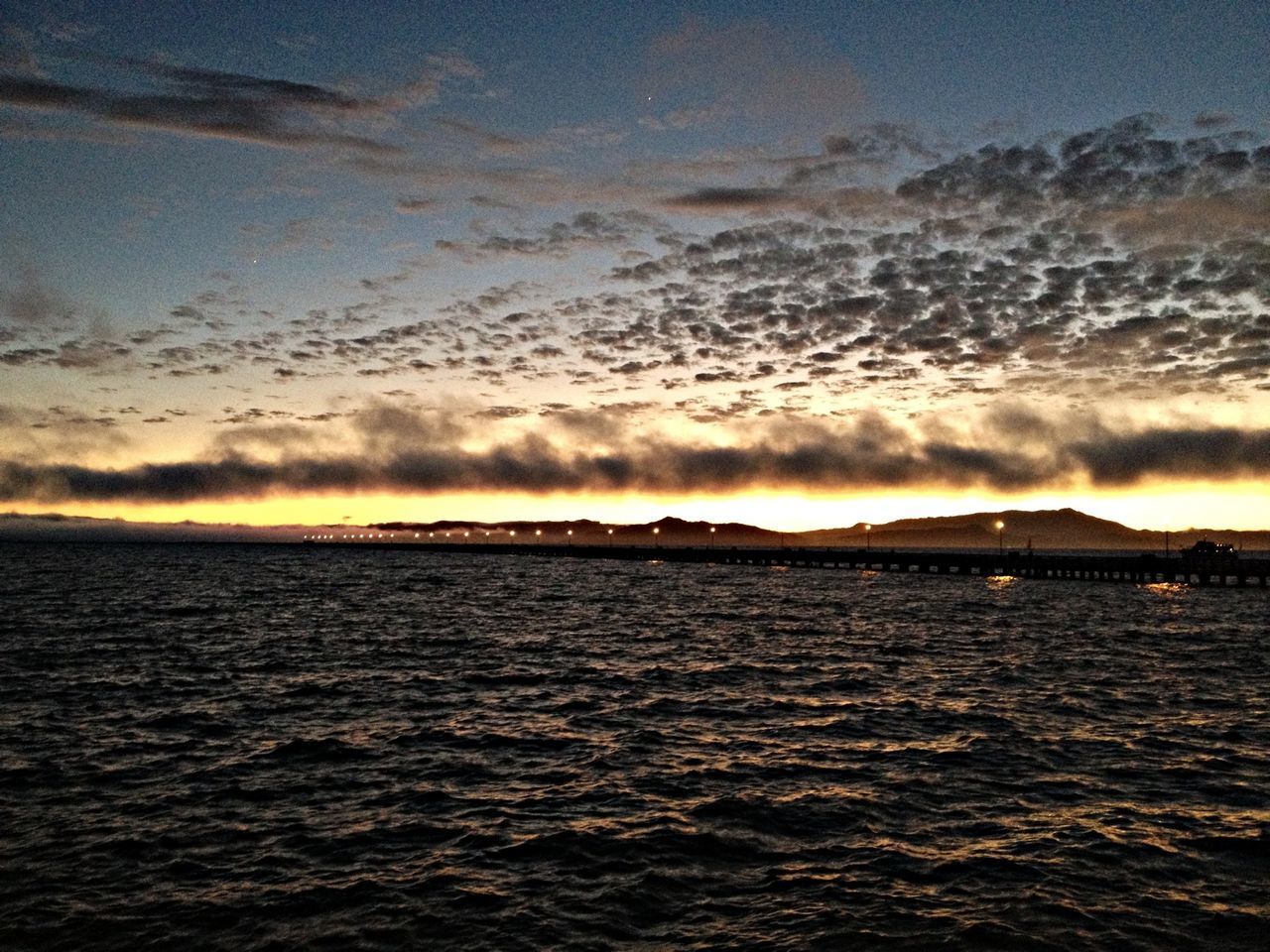 water, scenics, sunset, sea, waterfront, beauty in nature, sky, tranquil scene, tranquility, nature, cloud - sky, idyllic, rippled, cloud, outdoors, dramatic sky, no people, river, sunlight, horizon over water