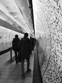 Rear view of people walking at underground walkway
