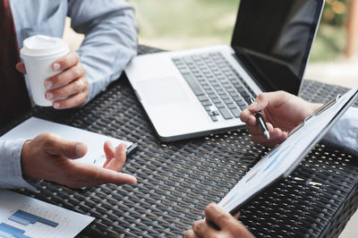 Midsection of man using laptop on table