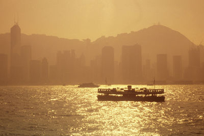 Boats in sea against sky during sunset