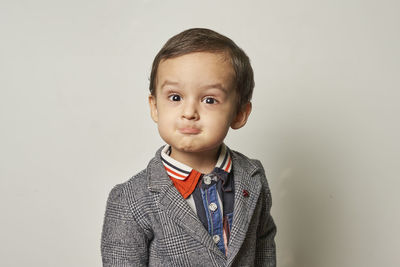 Portrait of boy standing against wall