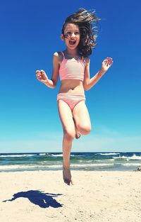 Portrait of  young woman/ girl jumping at beach