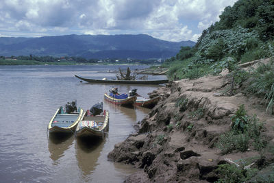 People on boat in mountains against sky