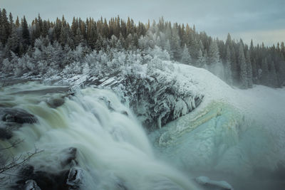 Blurred motion of waterfall in forest during winter