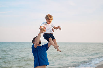 Father carrying son at beach