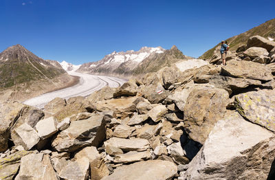 View of rocks and glacier in mountains against clear blue sky