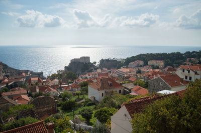 Aerial view of town by sea against sky