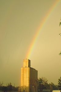 Low angle view of rainbow over built structures