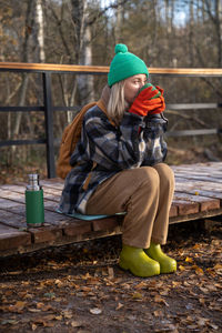 Side view of woman sitting on field