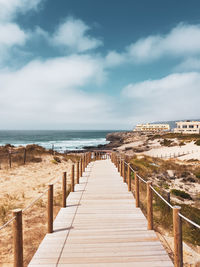 Wooden posts on beach against sky