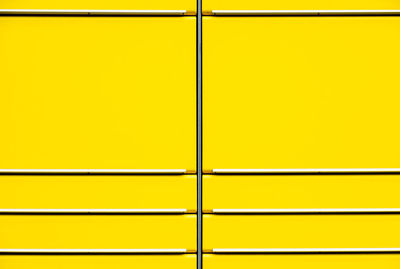 Full frame shot of yellow wall seen through metal grate